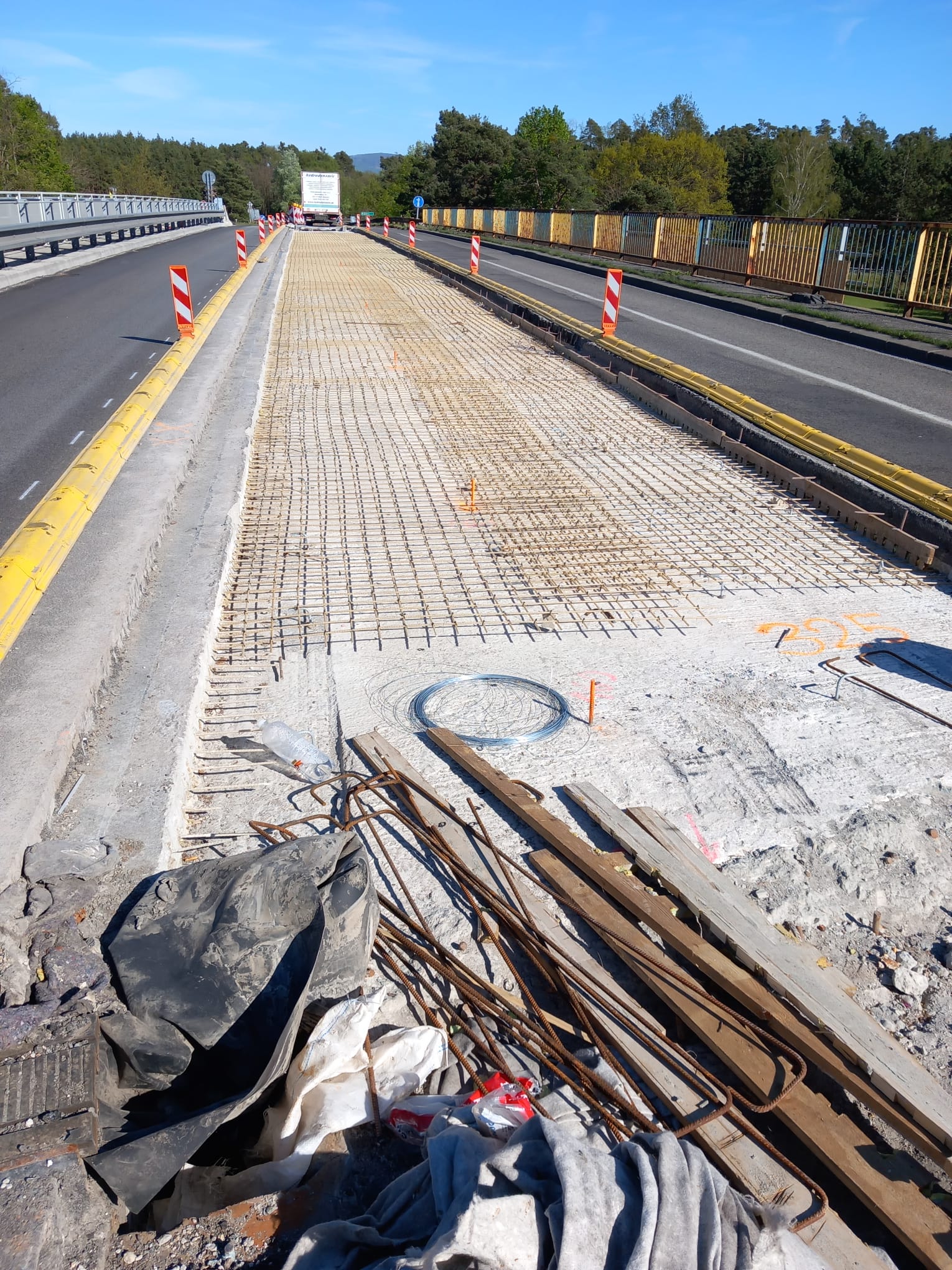 Malla de acero corroída retirada de un tablero de puente, junto al refuerzo GFRP nuevo